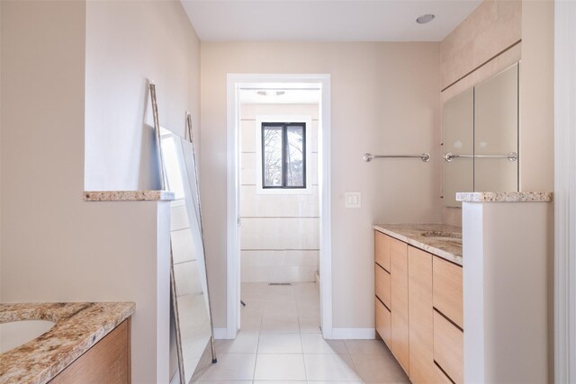 bathroom featuring tile patterned flooring, two vanities, and baseboards