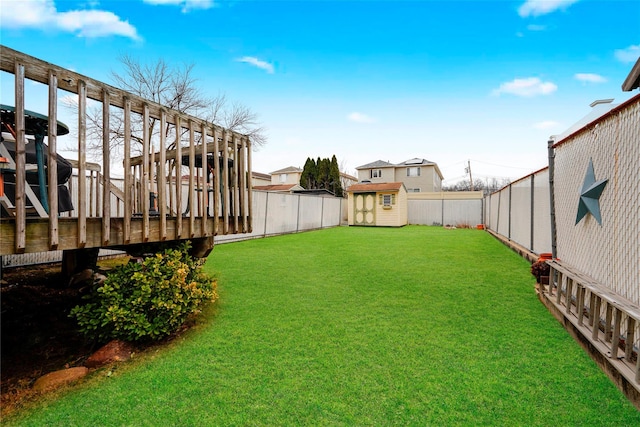 view of yard with a fenced backyard, a storage unit, and an outdoor structure