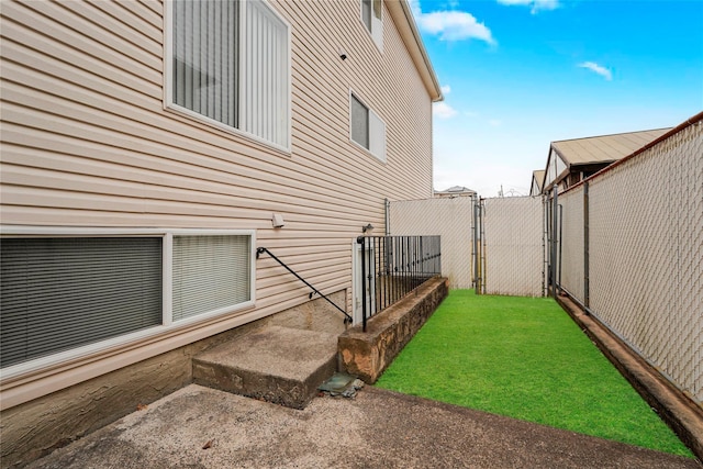 view of home's exterior with a gate, fence, and a lawn