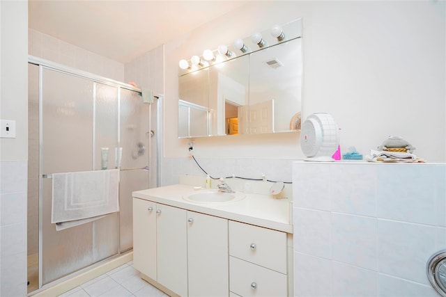 bathroom featuring tile patterned flooring, a shower stall, vanity, and visible vents