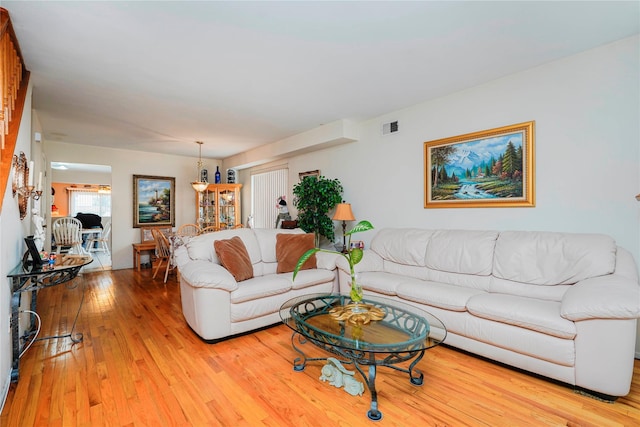 living area with visible vents and light wood-style floors