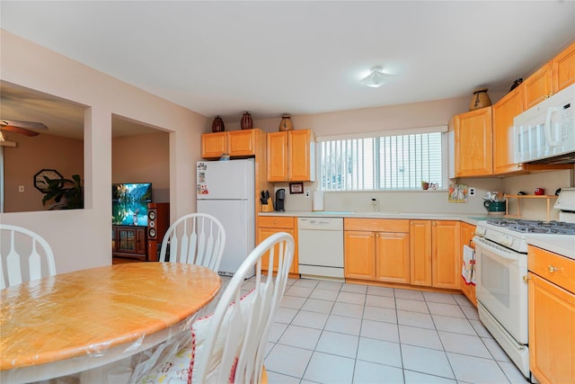 kitchen featuring a ceiling fan, a sink, white appliances, light countertops, and light tile patterned floors