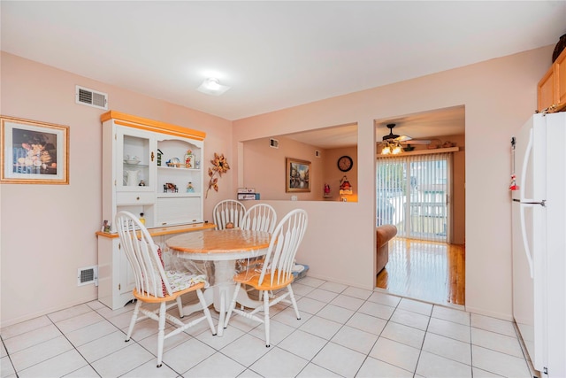 dining room featuring light tile patterned floors, visible vents, built in shelves, and ceiling fan