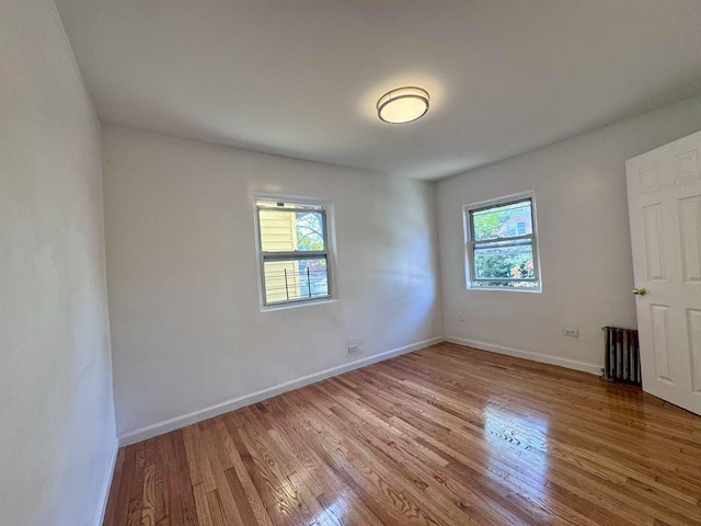 94-17 42nd Ave, Elmhurst, NY 11373 - unfurnished bedroom with baseboards, light wood-type flooring, and multiple windows