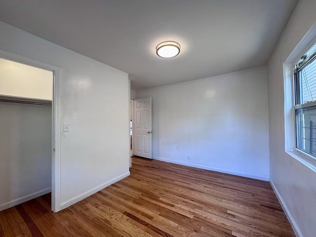 94-17 42nd Ave, Elmhurst, NY 11373 - unfurnished bedroom with a closet, wood finished floors, and baseboards