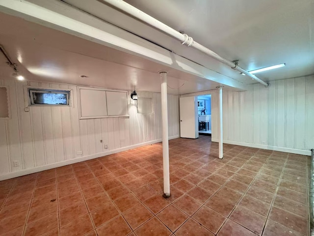 94-17 42nd Ave, Elmhurst, NY 11373 - finished below grade area with rail lighting, a decorative wall, tile patterned flooring, and baseboards