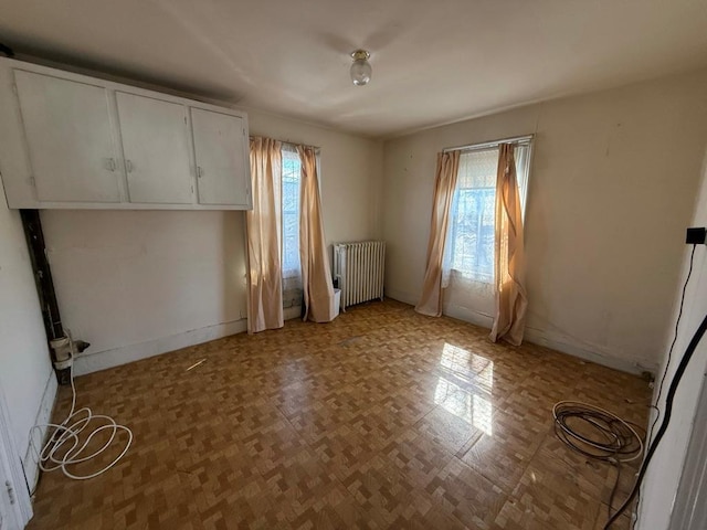 interior space featuring a wealth of natural light, radiator, and baseboards