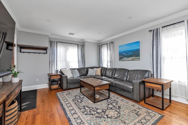 living room featuring crown molding, wood finished floors, visible vents, and baseboards