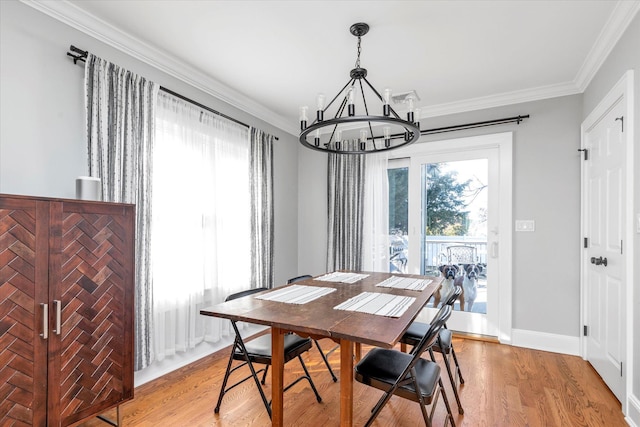 dining area featuring an inviting chandelier, plenty of natural light, and light wood-style floors