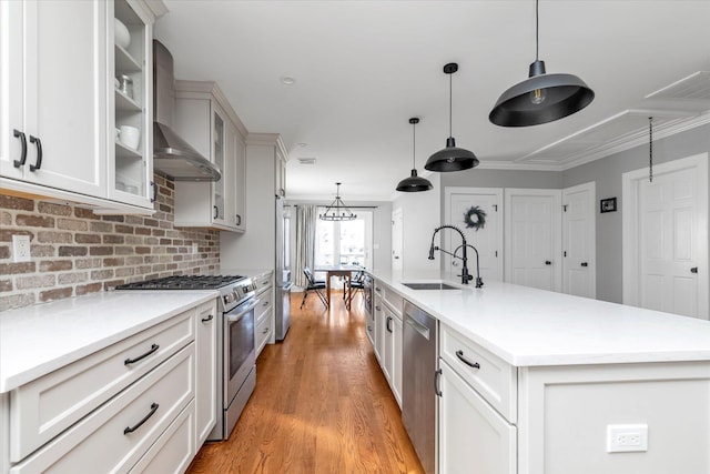 kitchen featuring light wood-type flooring, a sink, stainless steel appliances, light countertops, and glass insert cabinets