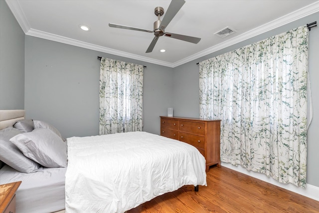 bedroom with crown molding, recessed lighting, wood finished floors, and visible vents