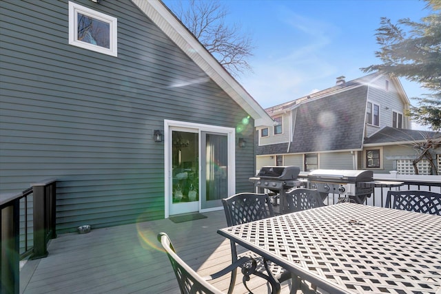 wooden terrace with outdoor dining space and grilling area