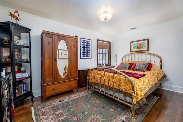 bedroom featuring visible vents, baseboards, and dark wood-style flooring