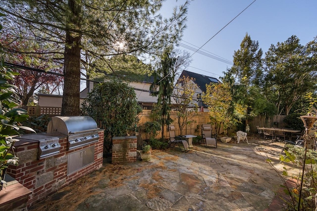 view of patio / terrace with area for grilling, fence, and a grill