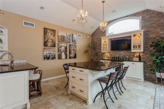 kitchen featuring a breakfast bar area, visible vents, and a sink