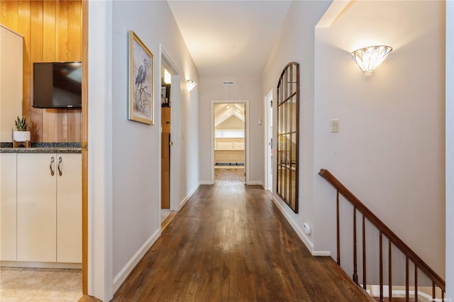 corridor featuring visible vents, wood finished floors, and baseboards