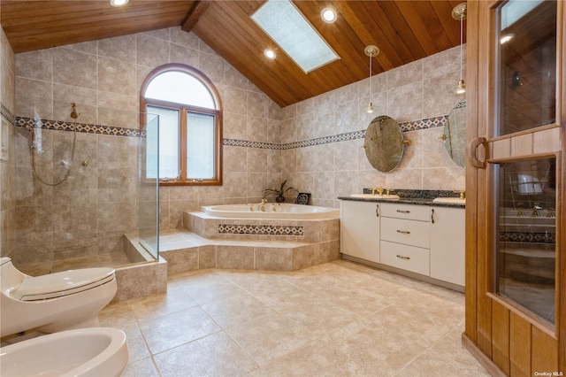 full bath with lofted ceiling with skylight, vanity, a garden tub, a tile shower, and tile walls