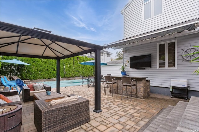 view of patio / terrace with a covered pool, outdoor dry bar, and an outdoor hangout area