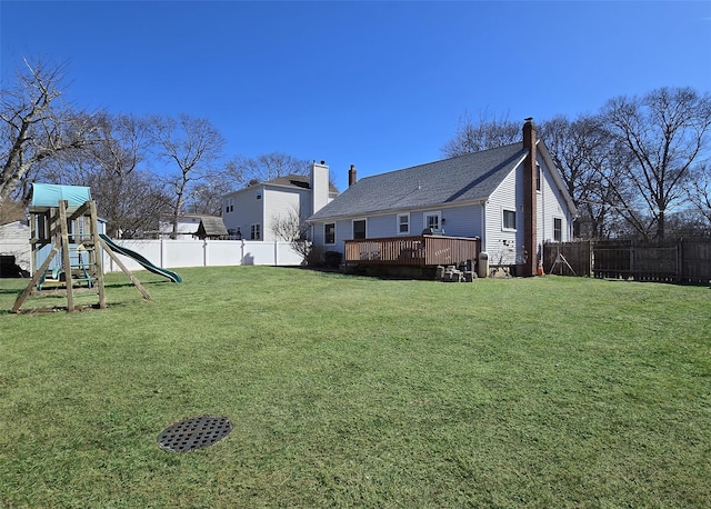 view of yard with a playground, a fenced backyard, and a wooden deck