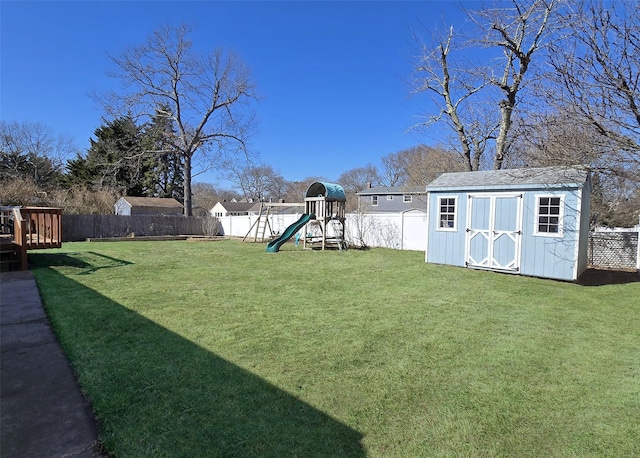 view of yard with a playground, an outdoor structure, a storage shed, and a fenced backyard