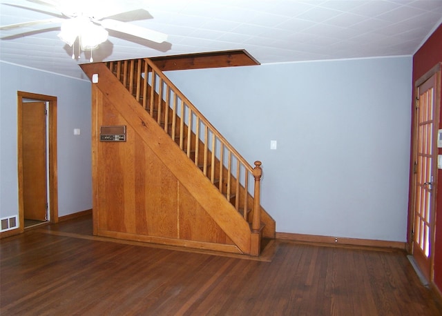 stairway featuring visible vents, baseboards, wood finished floors, and a ceiling fan