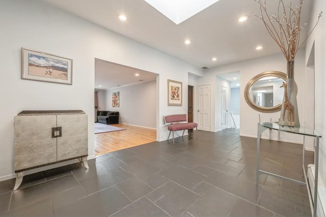 corridor featuring a skylight, recessed lighting, and baseboards