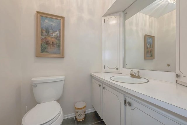 half bath with vanity, toilet, and baseboards