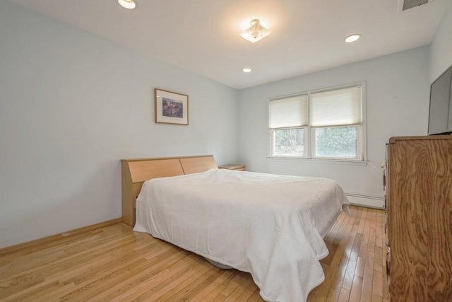 bedroom featuring recessed lighting, a baseboard radiator, baseboards, and light wood-style floors