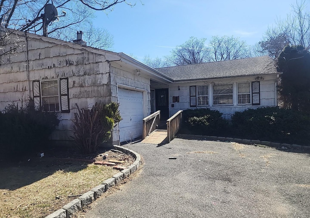 ranch-style home with an attached garage and driveway