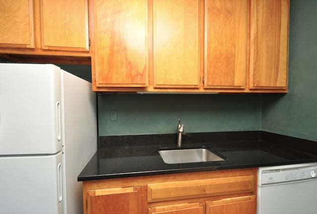 kitchen featuring white appliances and a sink