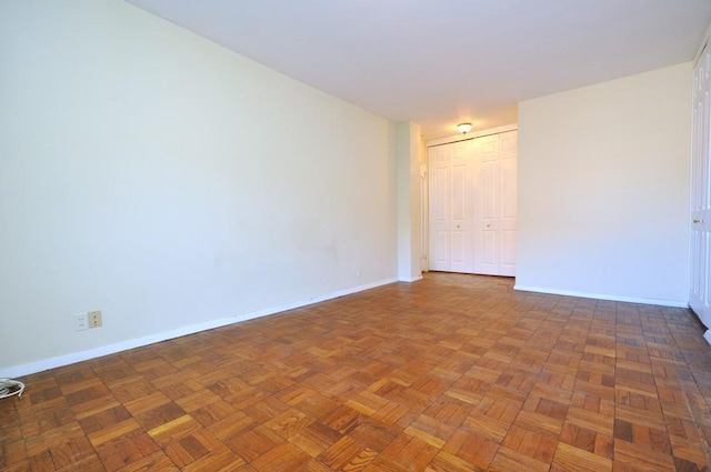 unfurnished room with baseboards