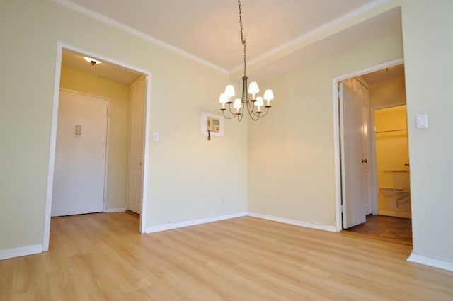 spare room with crown molding, a notable chandelier, baseboards, and light wood-type flooring