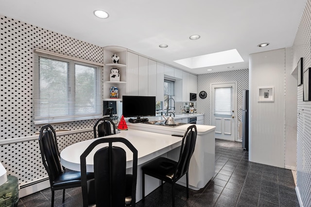 dining area featuring recessed lighting, baseboard heating, a skylight, and granite finish floor