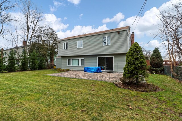 rear view of property featuring fence, a lawn, and a patio area