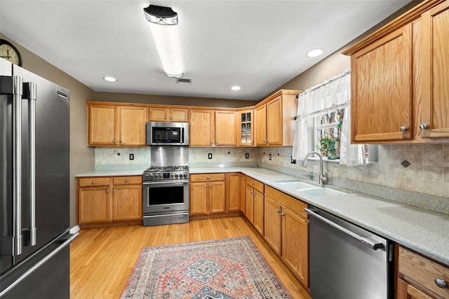 kitchen featuring visible vents, light wood finished floors, a sink, light countertops, and appliances with stainless steel finishes