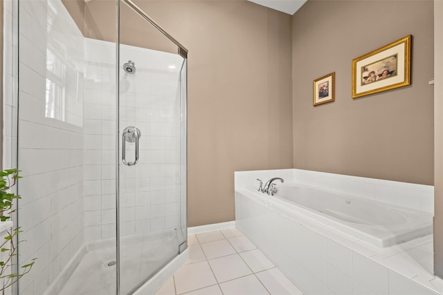 bathroom with tile patterned flooring, a bath, baseboards, and a stall shower