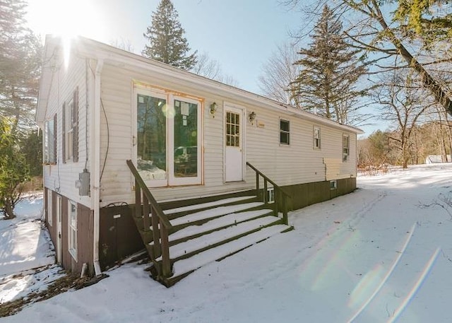 view of snow covered back of property