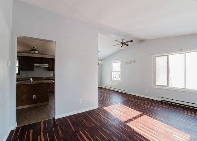 unfurnished living room with a baseboard heating unit, ceiling fan, baseboards, vaulted ceiling, and dark wood-style flooring