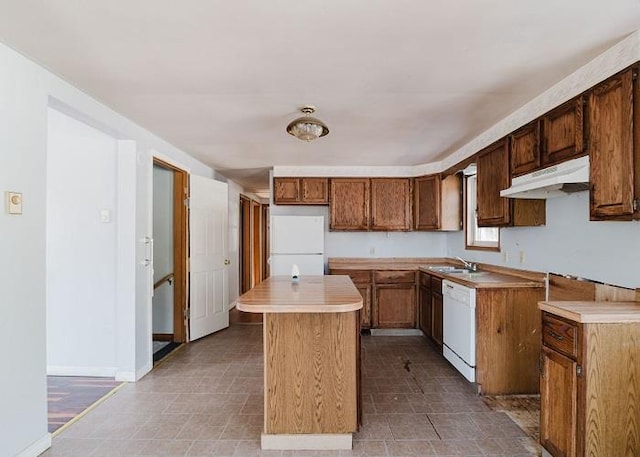 kitchen with a kitchen island, baseboards, under cabinet range hood, light countertops, and white appliances