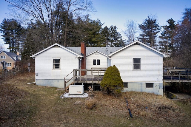 rear view of house with a deck and a chimney