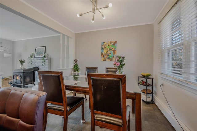 dining space featuring dark tile patterned floors, a wood stove, baseboards, and ornamental molding