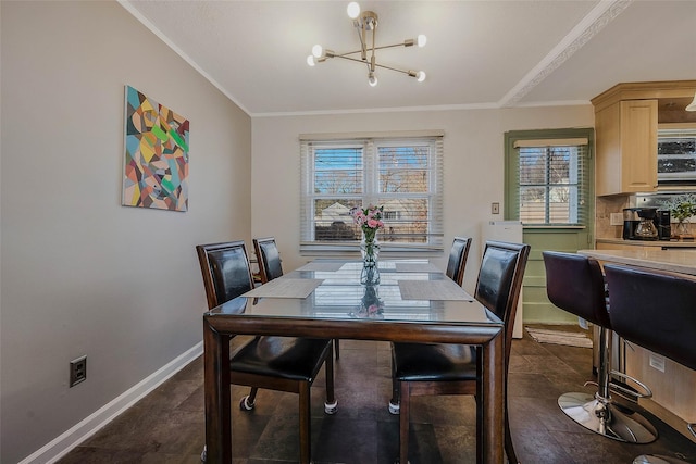 dining room with a chandelier, baseboards, and ornamental molding