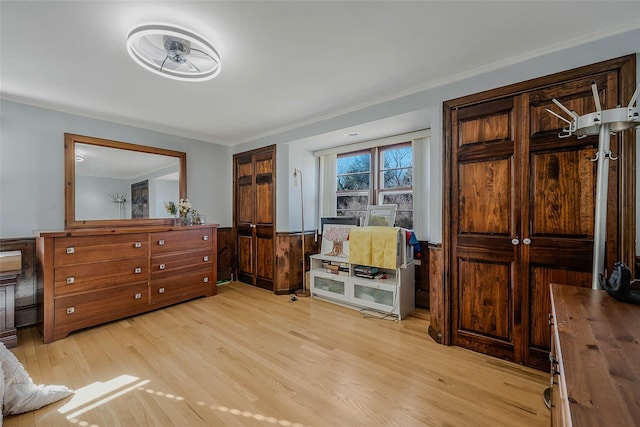 bedroom with light wood-style floors and wainscoting