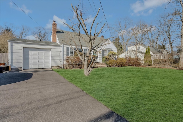 view of front of house featuring aphalt driveway, an attached garage, a front lawn, and a chimney