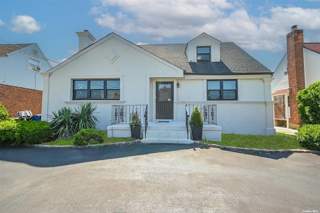 view of front of house featuring stucco siding and roof with shingles