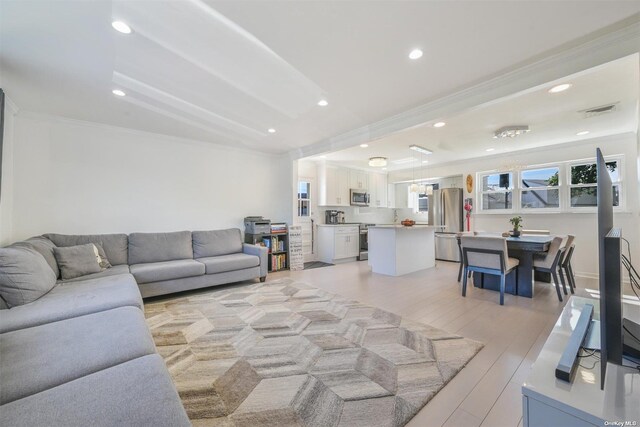 living area featuring visible vents, recessed lighting, crown molding, and light wood-type flooring