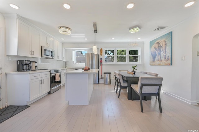 kitchen featuring visible vents, backsplash, light countertops, white cabinets, and stainless steel appliances