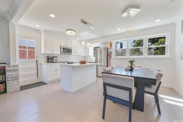 kitchen featuring white cabinetry, backsplash, appliances with stainless steel finishes, and a center island