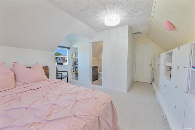 bedroom featuring visible vents, a textured ceiling, connected bathroom, light colored carpet, and vaulted ceiling