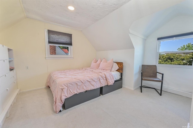 bedroom featuring lofted ceiling, carpet flooring, baseboards, and a textured ceiling